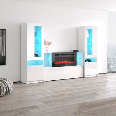 a white entertainment center with a fireplace in the middle and blue lights on it's sides