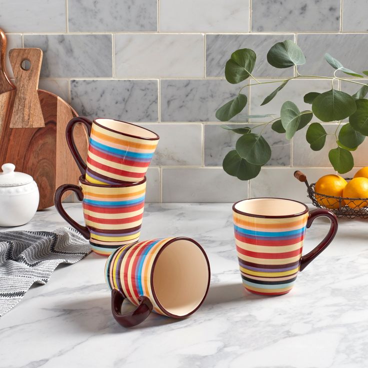 four coffee cups sitting on top of a marble counter