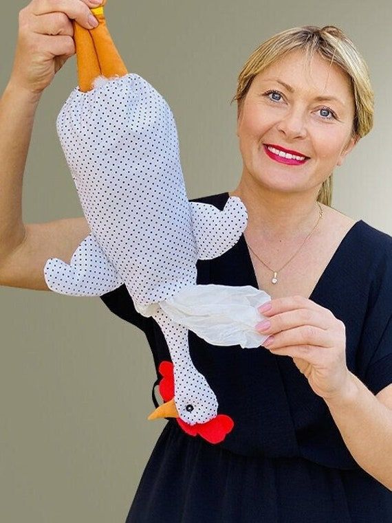 a woman holding up a carrot shaped like a bird with a chicken on it's back