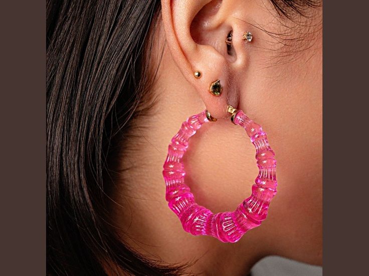 14K yellow gold over sterling silver bamboo hoops electric pink. Our bamboo hoops are a Queens must-have. These are a classic 90s hoop, but with a 2022 twist! These are one of our best selling items. The glass like acrylic makes these hoops shine. Trendy Pink Round Hoop Earrings, Trendy Pink Beaded Hoop Earrings, Trendy Pink Hoop Jewelry, Modern Pink Hoop Earrings, Trendy Pink Hoop Earrings For Summer, Trendy Pink Hoop Earrings For Everyday, Everyday Pink Hoop Earrings, Twist, Yellow Gold