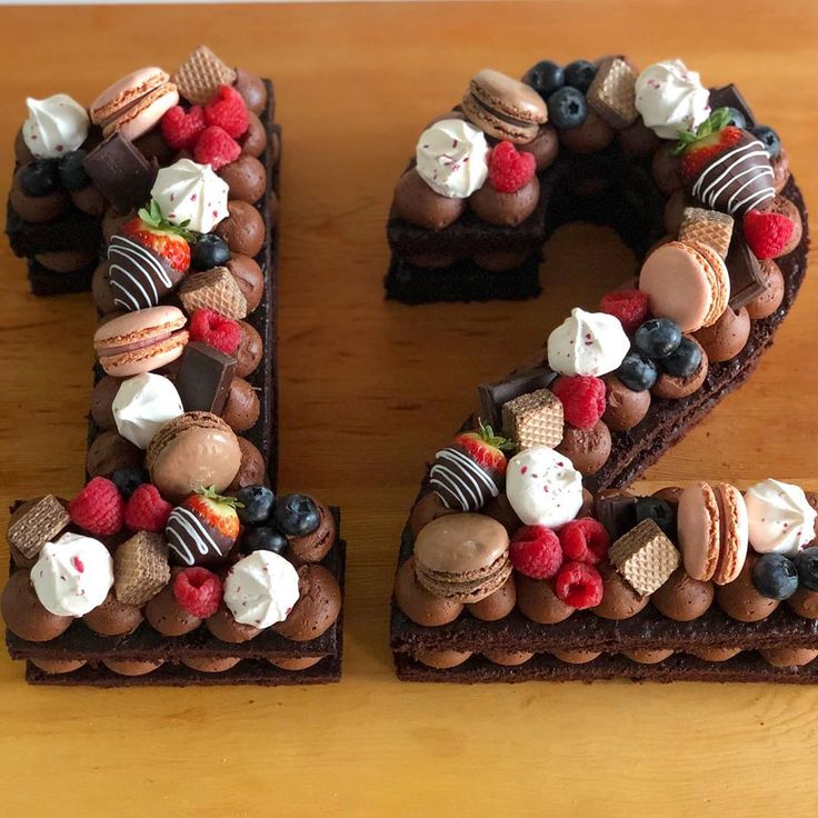 the letter e is made out of chocolate cake and decorated with berries, strawberries, blueberries, raspberries