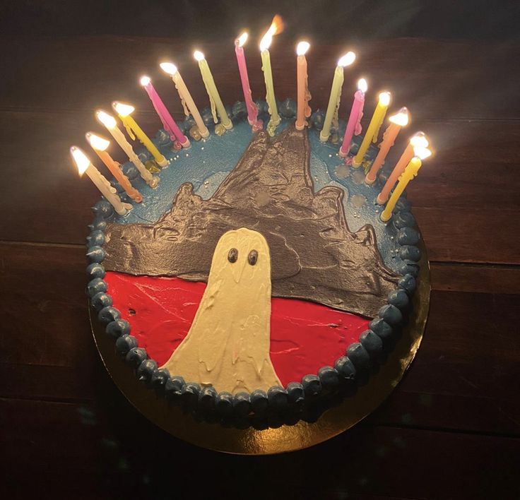 a cake decorated with candles and a ghost on it