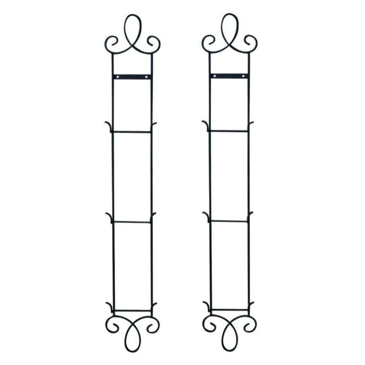 two tall black iron plant stands with scroll designs on each side and one long metal rod at the top