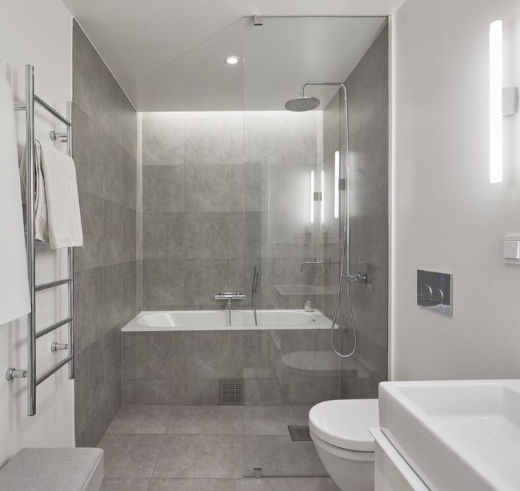 a bathroom with a toilet, sink and bathtub next to a shower head mounted on the wall