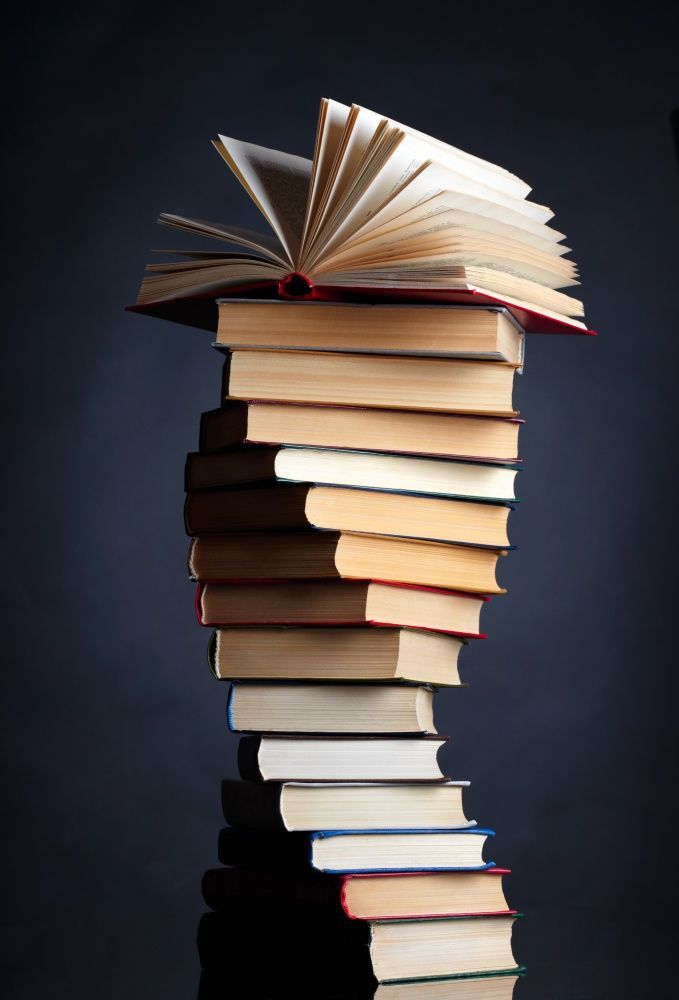 a stack of books sitting on top of each other in front of a black background