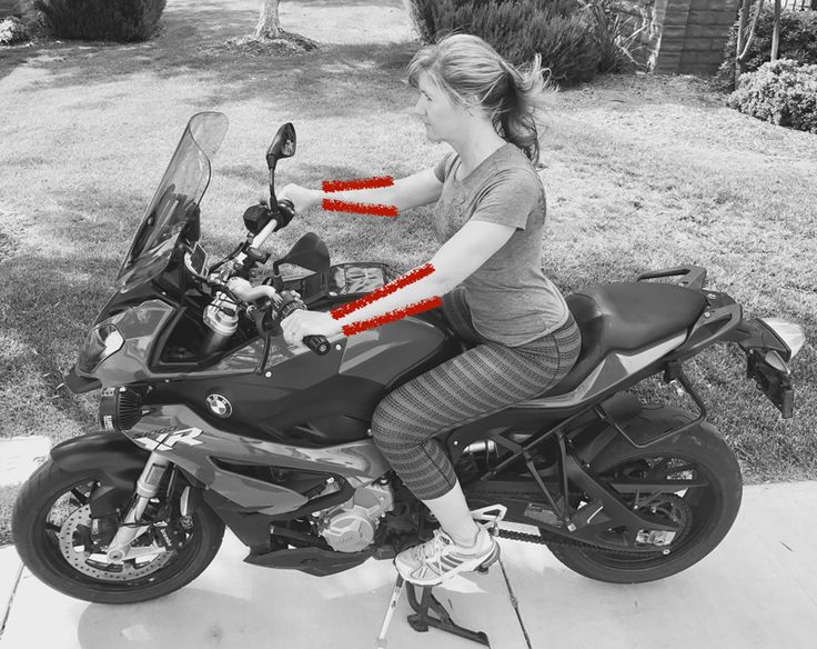 black and white photograph of a woman on a motorcycle with red tape around the seat