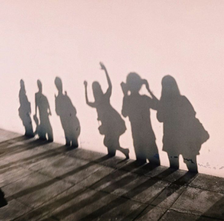 several people are standing on the edge of a wall and shadow is cast over them