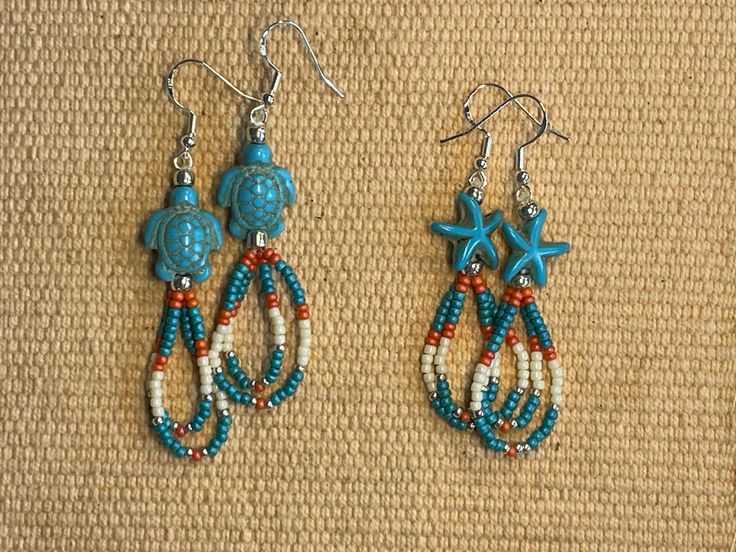 These earrings are perfect for the summer or anytime for beach fans.  One set has turtles and the other set has sea stars.  The colors are "beach themed."  The length measures 2 inches in length. Beaded Earrings With Ear Wire For Beach, Adjustable Beaded Earrings With Ear Wire For Beach, Handmade Adjustable Earrings For Beach Season, Handmade Beaded Earrings For Beach, Nickel-free Multicolor Jewelry For Beach, Nickel-free Multicolor Jewelry For The Beach, Handmade Starfish Earrings For Beach, Handmade Starfish Earrings For Summer, Adjustable Beaded Earrings With Dangling Beads For Beach