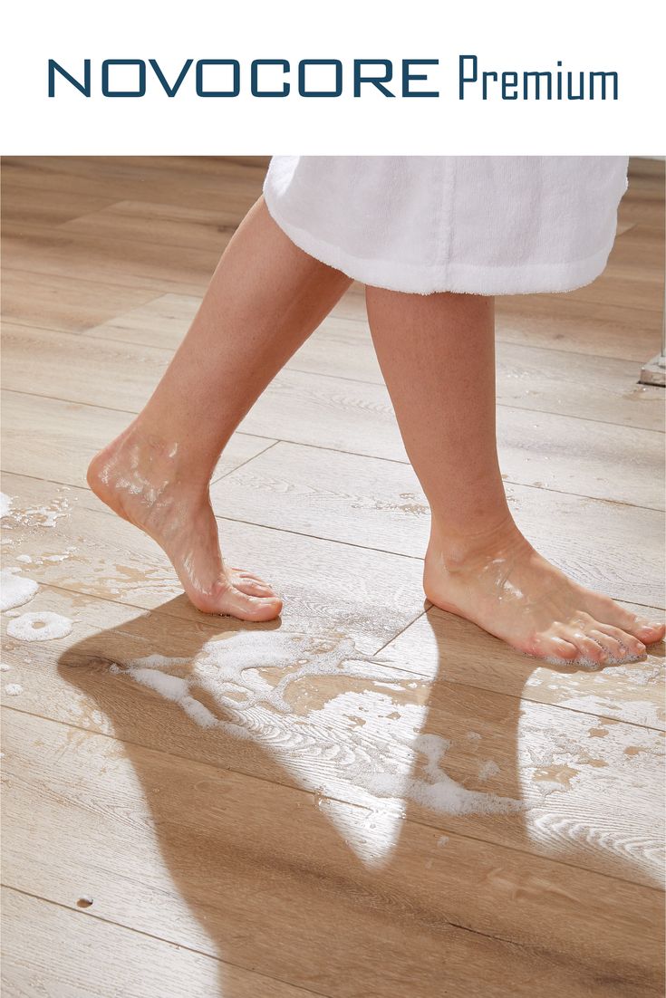 a person standing on top of a wooden floor with their bare feet in the water