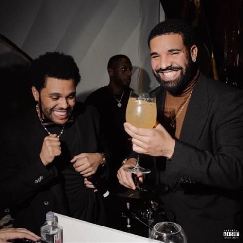 two men holding wine glasses in their hands and laughing at the camera while another man looks on