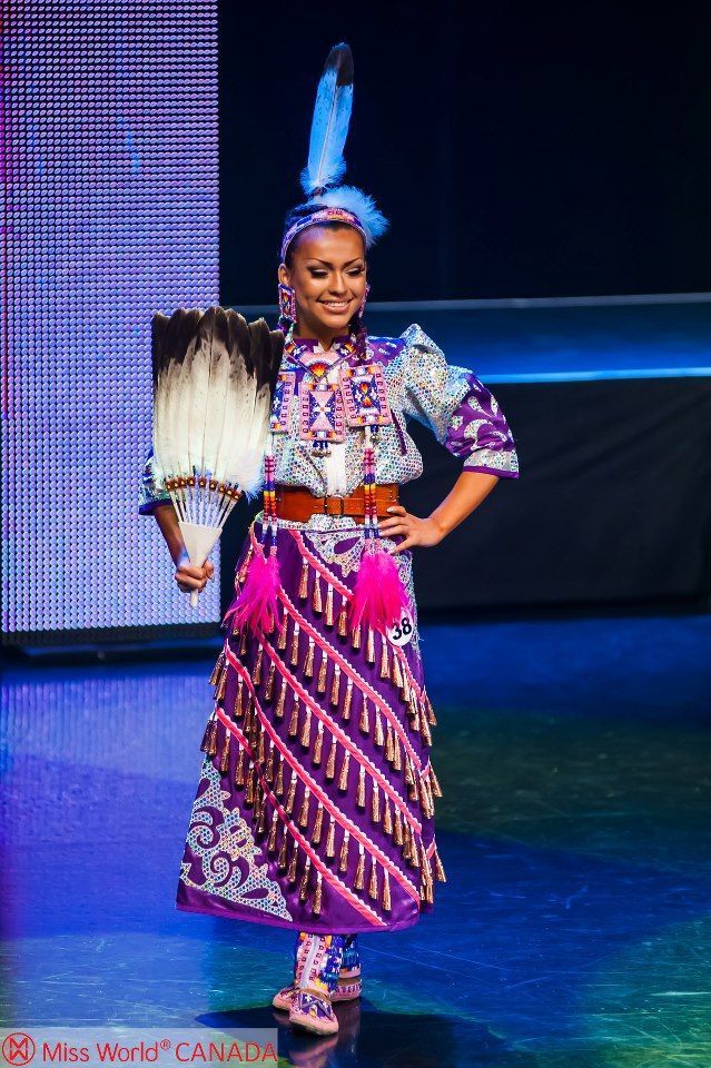 a woman is standing on the stage with her hand in her pocket and wearing an elaborate headdress