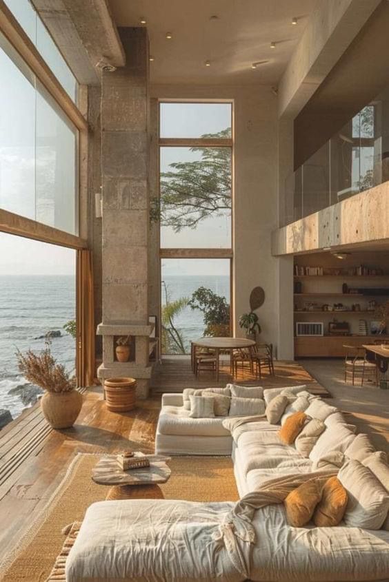 a living room filled with lots of furniture next to the ocean