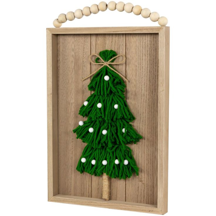 a wooden frame with a green christmas tree on the front and white balls around it