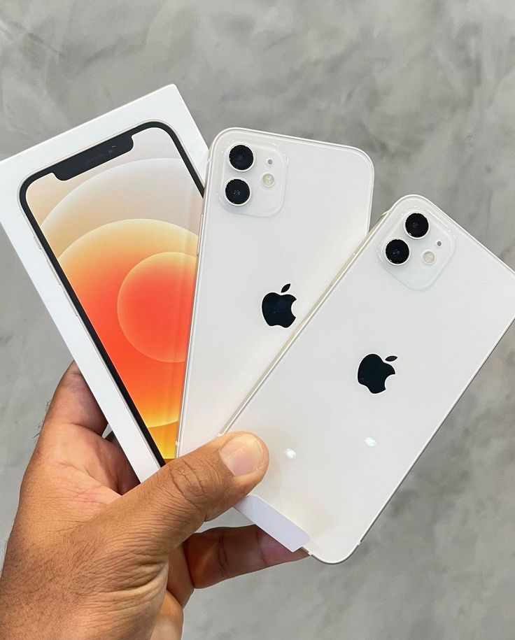 two white iphones being held in front of each other