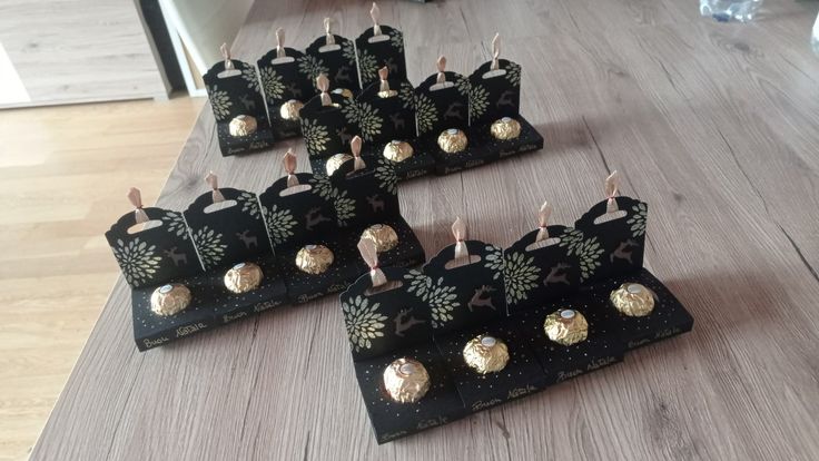 there are many black and gold desserts on the table with toothpicks in them