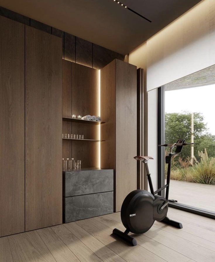 an exercise room with a stationary bike and shelves