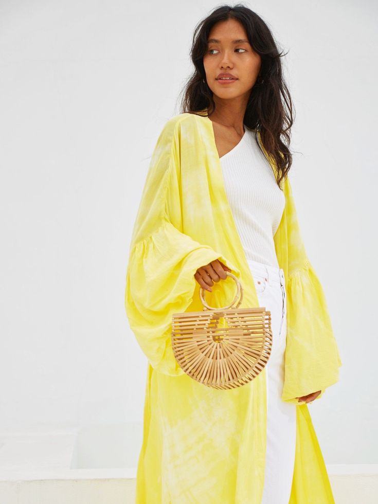 This marvelous Miko - Yellow Kimono Robe & Jacket is an excellent way to effortlessly bring impact to your look. Featuring a relaxed oversized fit in a handmade breathable fabric and enlivened with a cool yellow hue, this kimono will lift any outfit. Features: Soft feel Lightweight feel Very comfortable Handmade Oversized fit Puffy sleeves Oversized -One size all fit Removable waist tie closure with loops Side slits at hem No pockets Hand wash in cold water, hang dry Size + Fit Model height is w Casual Cotton Beach Outerwear, Oversized Chic Outerwear For Beach, Chic Oversized Outerwear For The Beach, Casual Beach Outerwear, Casual Oversized Summer Outerwear, Casual Summer Outerwear For Day Out, Trendy Cotton Beach Outerwear, Casual Cotton Outerwear For Vacation, Relaxed Fit Cotton Outerwear For Vacation