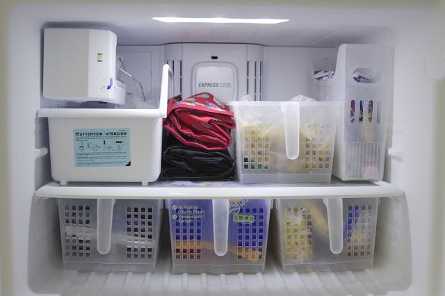 an open refrigerator filled with lots of plastic containers