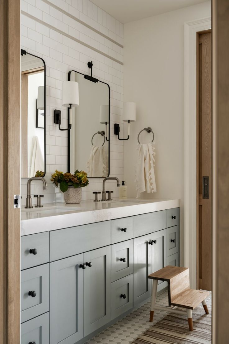 a bathroom with two sinks and mirrors on the wall