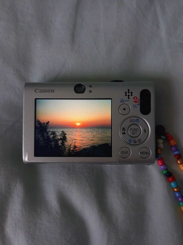 a camera is sitting on a bed with beads