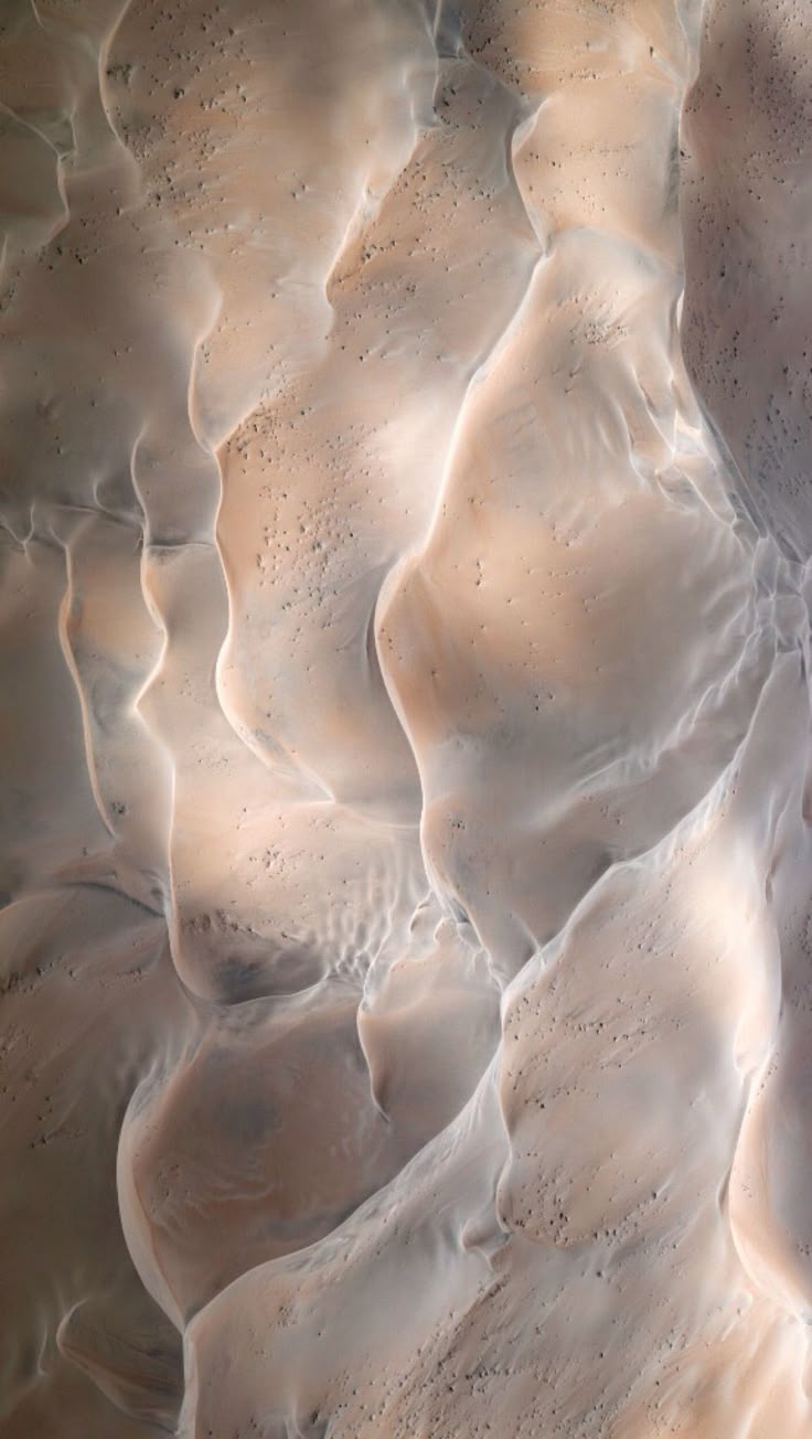 an aerial view of sand and water in the desert, looking down at it's surface