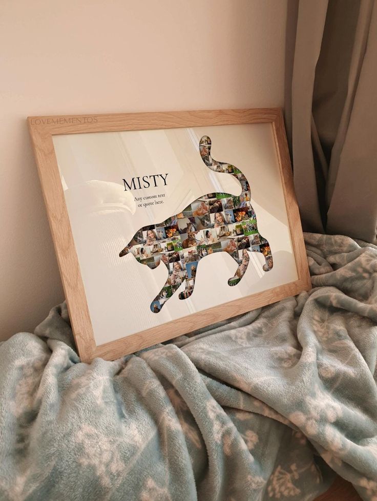 a framed photo of a cat with the word misty on it's side, sitting on a bed