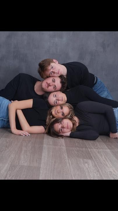 four people laying on the floor posing for a photo