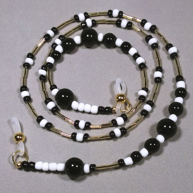 This eyeglasses chain is made with graduated sizes of round black glass beads, black and white glass seed beads and shiny gold colored bugle beads. The neutral colors will go with anything and will be a great gift for either a man or woman. Length - 28" (71.12 cm) Weight - 1.27 oz. (36 grams) Multi-strand stringing wire Silicone ends Black Glass Round Bead Jewelry, Black Glass Round Beads Jewelry, Black Glass Beaded Necklaces With Round Beads, Black Glass Beaded Necklace With Round Beads, Handmade Glass Beads In Black, Handmade Black Glass Beads, Black Glass Beaded Necklaces With Colorful Beads, Black Glass Beaded Necklace With Colorful Beads, Black Glass Beaded Jewelry