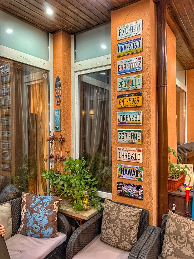 there are many chairs and couches on the outside of this house with signs on the wall