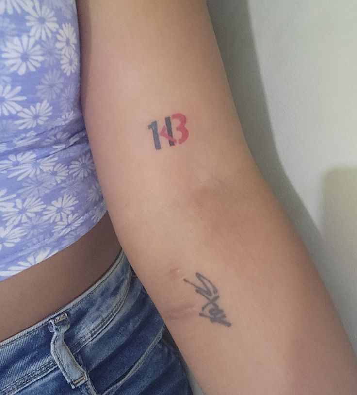 a woman with a tattoo on her arm has the number thirteen tattooed on her arm