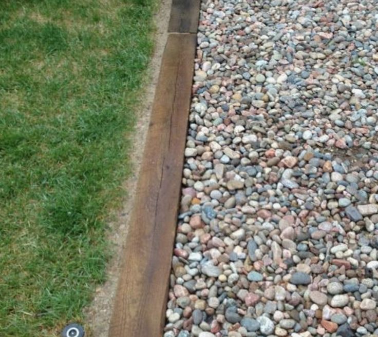 the grass is green and brown next to some rocks on the side of a road