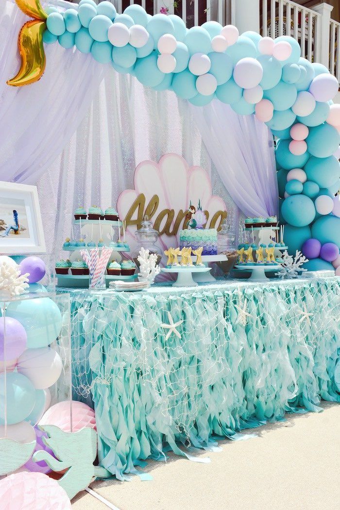 a table topped with lots of blue and pink balloons