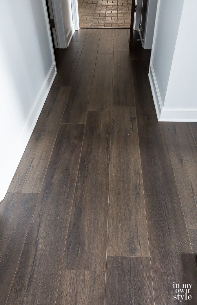 an empty hallway with wood flooring and white trim on the walls is seen in this image