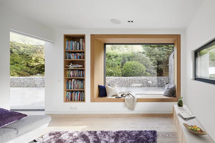 a bedroom with a window seat and bookshelf