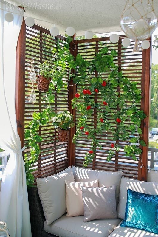 an outdoor living room with plants growing on the wall