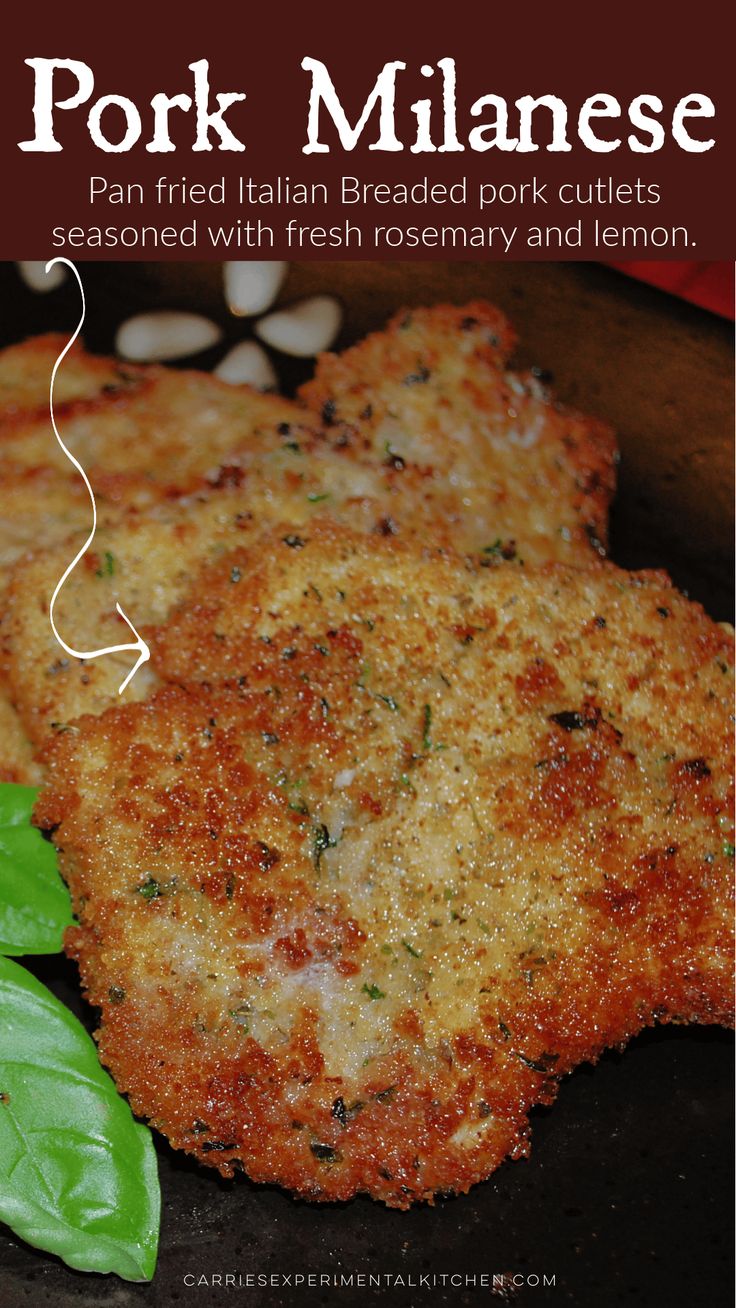 two pieces of fried breaded pork cutlets with fresh rosemary and lemon on the side