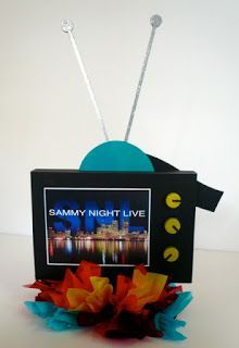 a photo frame sitting on top of a table next to some paper flowers and candles