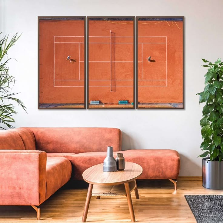 a living room with two couches and a tennis court on the wall above them