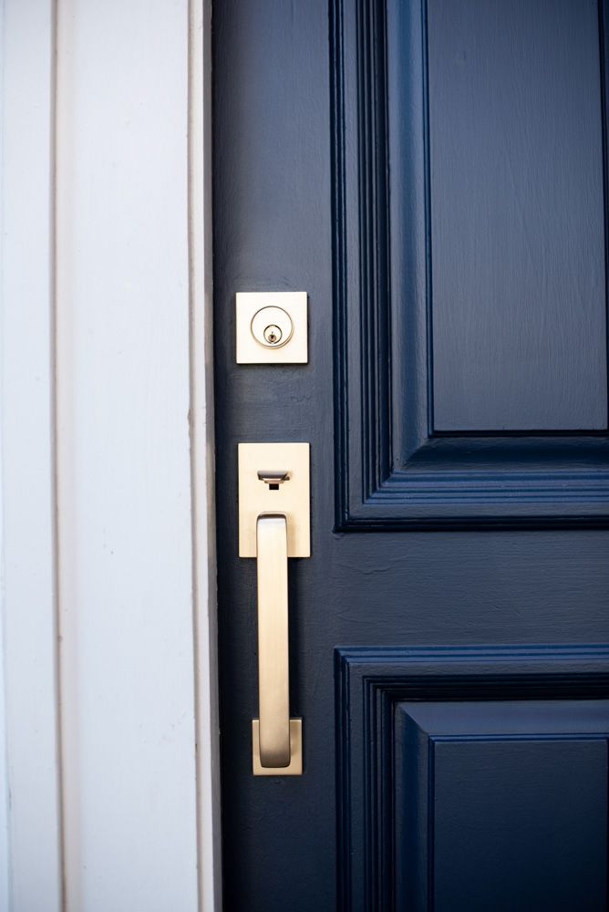 a close up of a door handle on a blue door