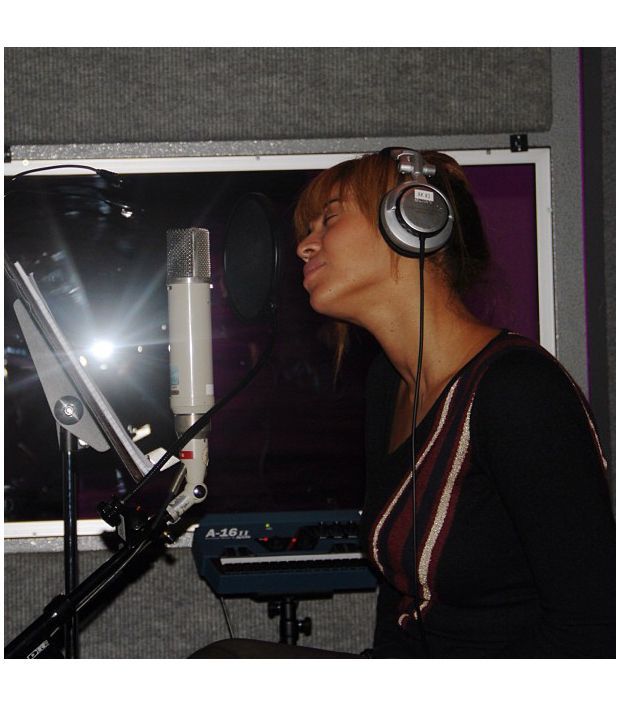 a woman sitting in front of a microphone with headphones on