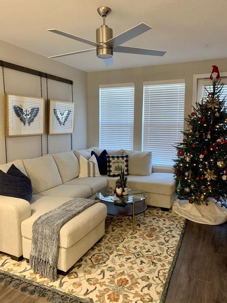 a living room filled with furniture and a christmas tree in the middle of the room