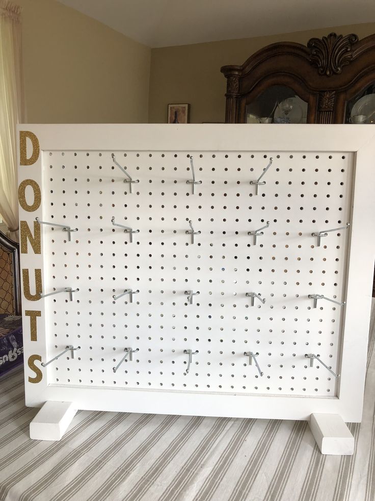 a white pegboard with numbers on it sitting in front of a dresser and mirror