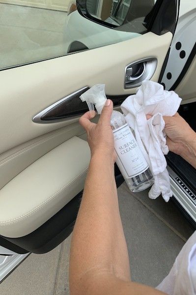 a person wiping up the inside of a car door with a cloth and rag on it