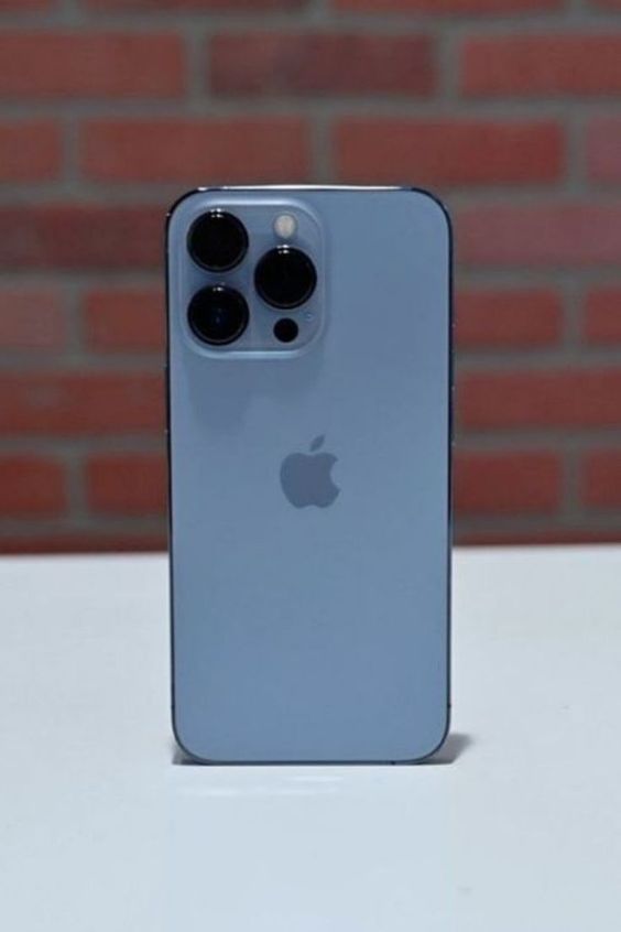 an iphone 11 pro sitting on top of a white table next to a brick wall