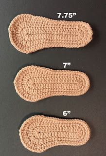 two crocheted feet are shown next to each other on a black surface with measurements