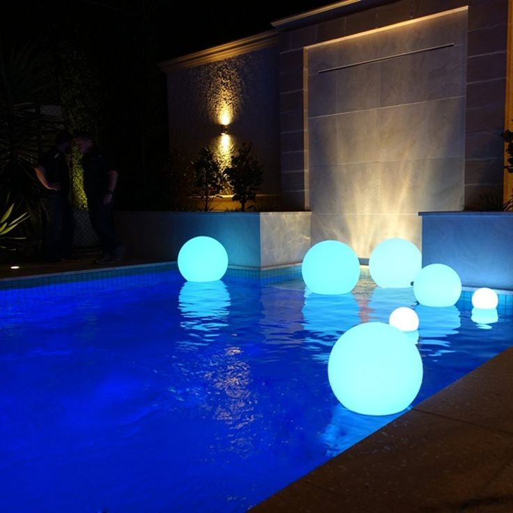 some lights that are on the side of a swimming pool