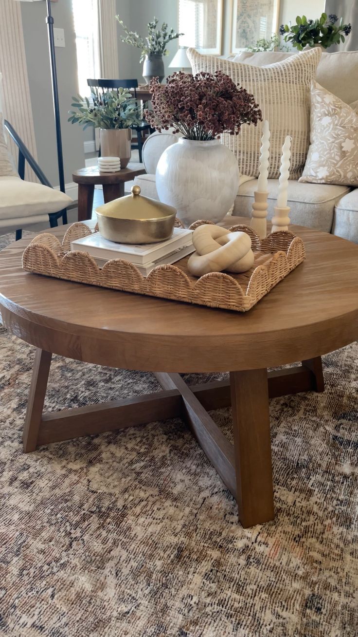 a living room with a couch, coffee table and vase on top of the coffee table