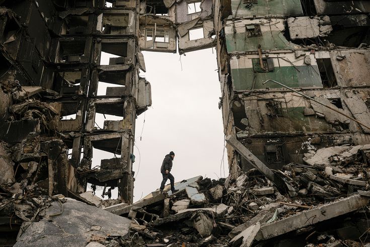 a man standing in the middle of a destroyed building