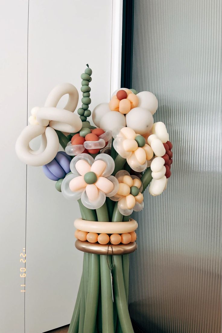 a vase filled with lots of different colored balloons