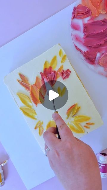 someone is painting flowers on a piece of paper with acrylic paint and watercolors